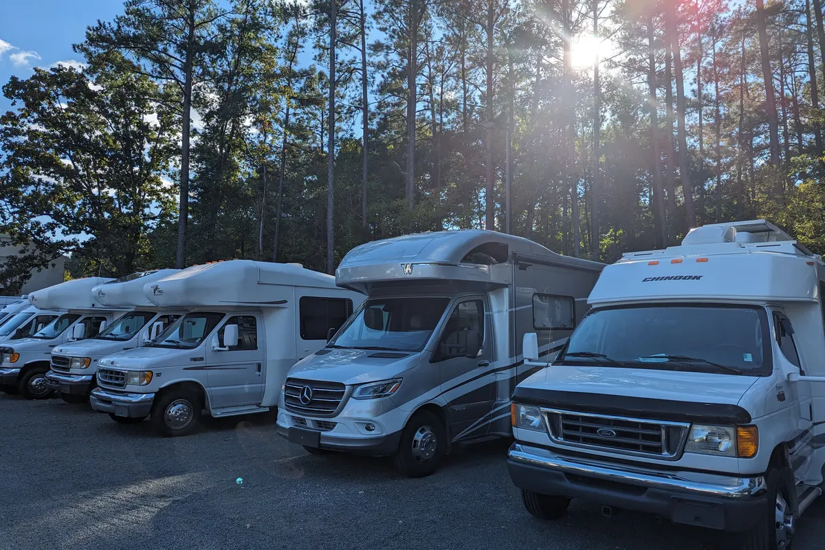 Class B and Class C motorhomes lined up under the pines at Stream RV in Creedmoor, NC
